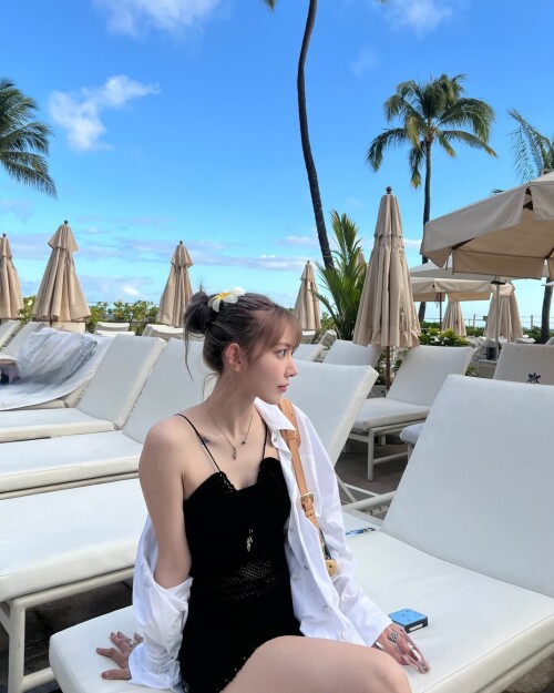 Photo by Sakura Miyawaki on September 24, 2024. May be an image of 1 person, pool, palm trees and ca